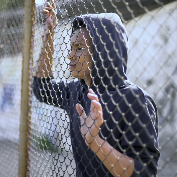 teenager standing be fence